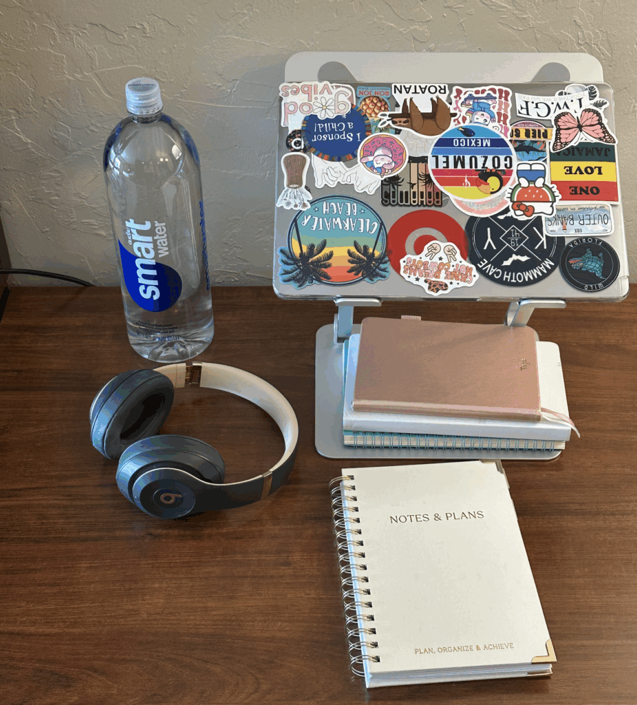 Picture of water bottle, laptop, headphones, and journal for business owner quarterly planning retreat