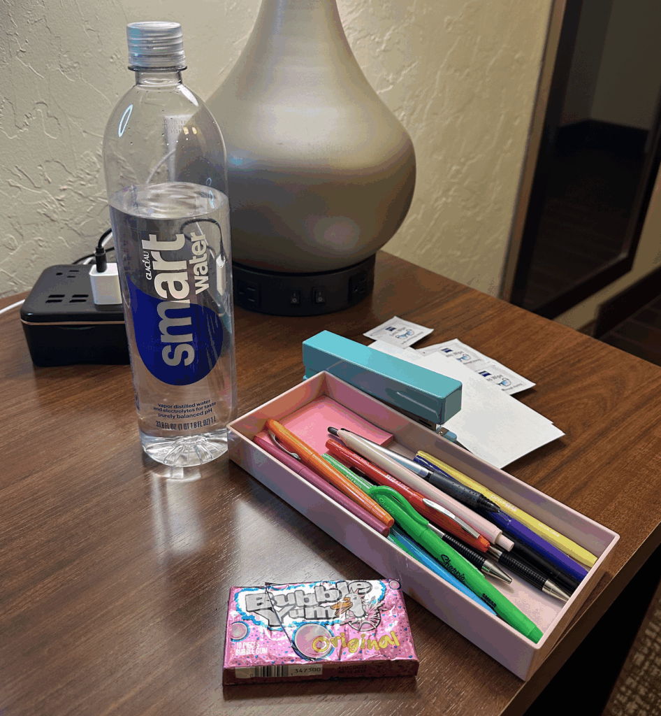 Picture of a water bottle, pens, stapler, gum, and other office supplies on desk for business owner's quarterly planning retreat